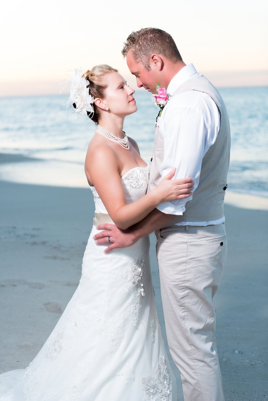Bride and groom standing close, looking into each other’s eyes at Miami beach during sunset, captured by Alito Photography.