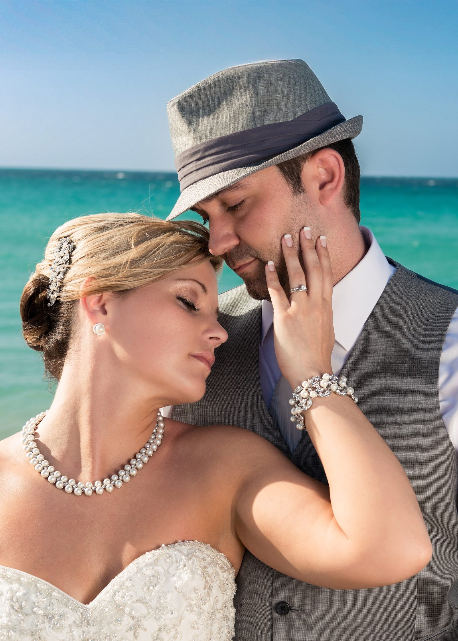 Bride leaning her head against groom’s chest, eyes closed, touching his face softly, romantic wedding portrait in Miami.