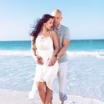 A newly engaged couple posing naturally on a Miami beach during sunset, captured by Alito Photography.