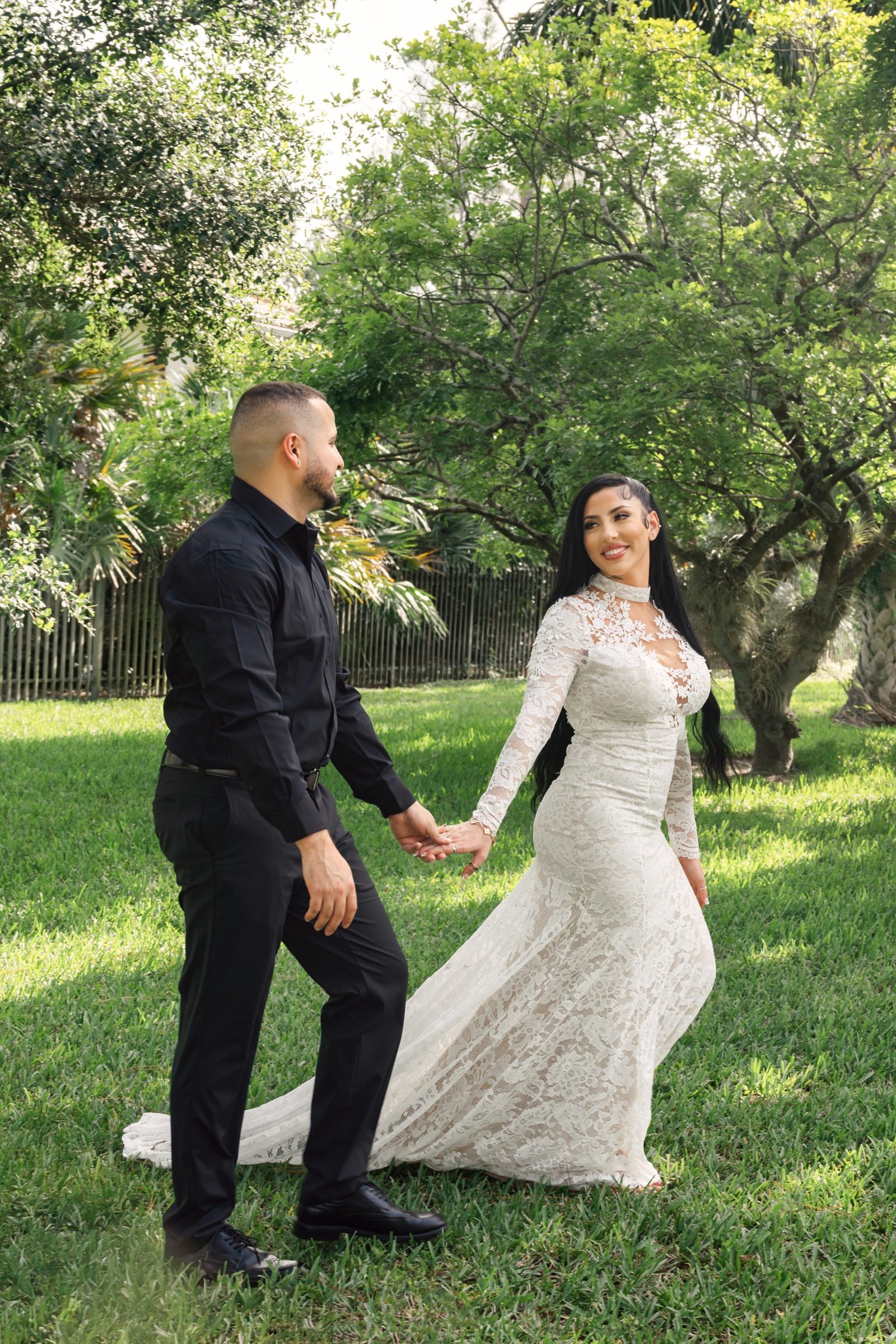 Miami wedding photographer captures a bride leading her groom by the hand in a romantic garden moment.