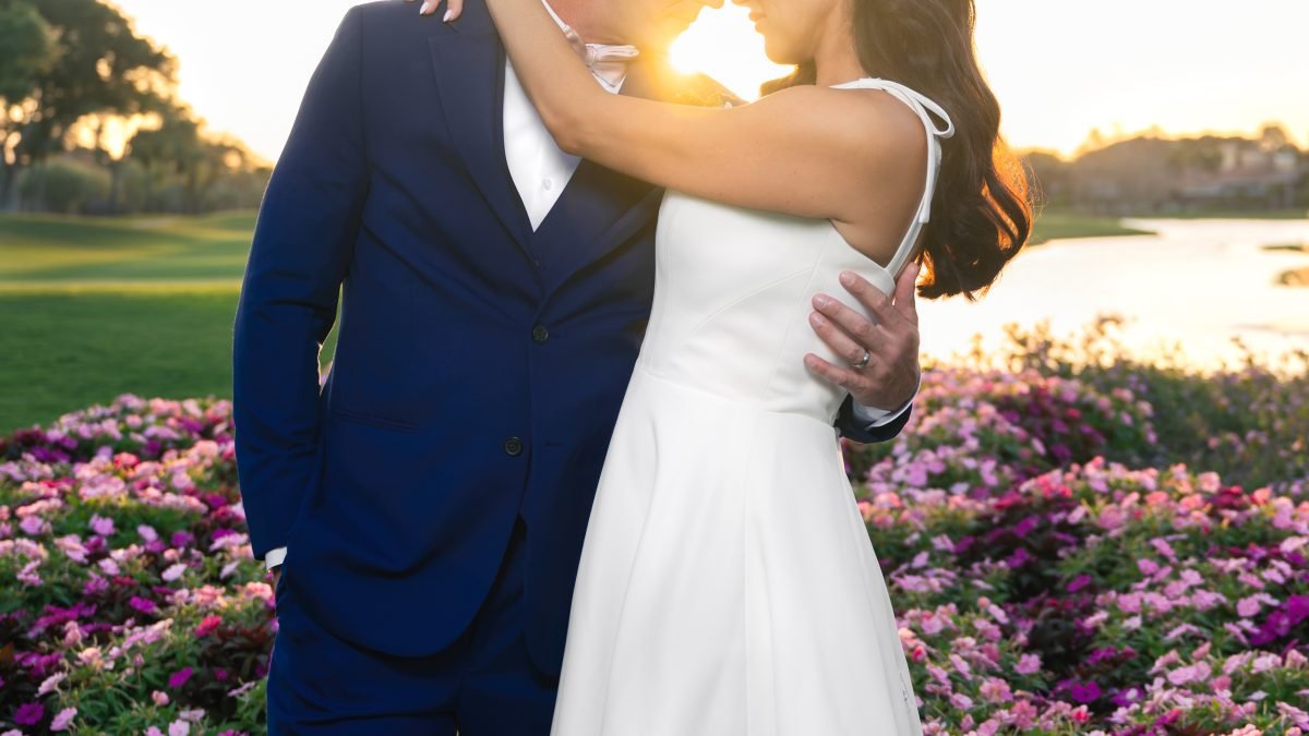 Bride and groom kissing with soft sun flare forming a circle of light during their wedding at The Club at Ibis in West Palm Beach, captured by Miami wedding photographer Alito Photography.