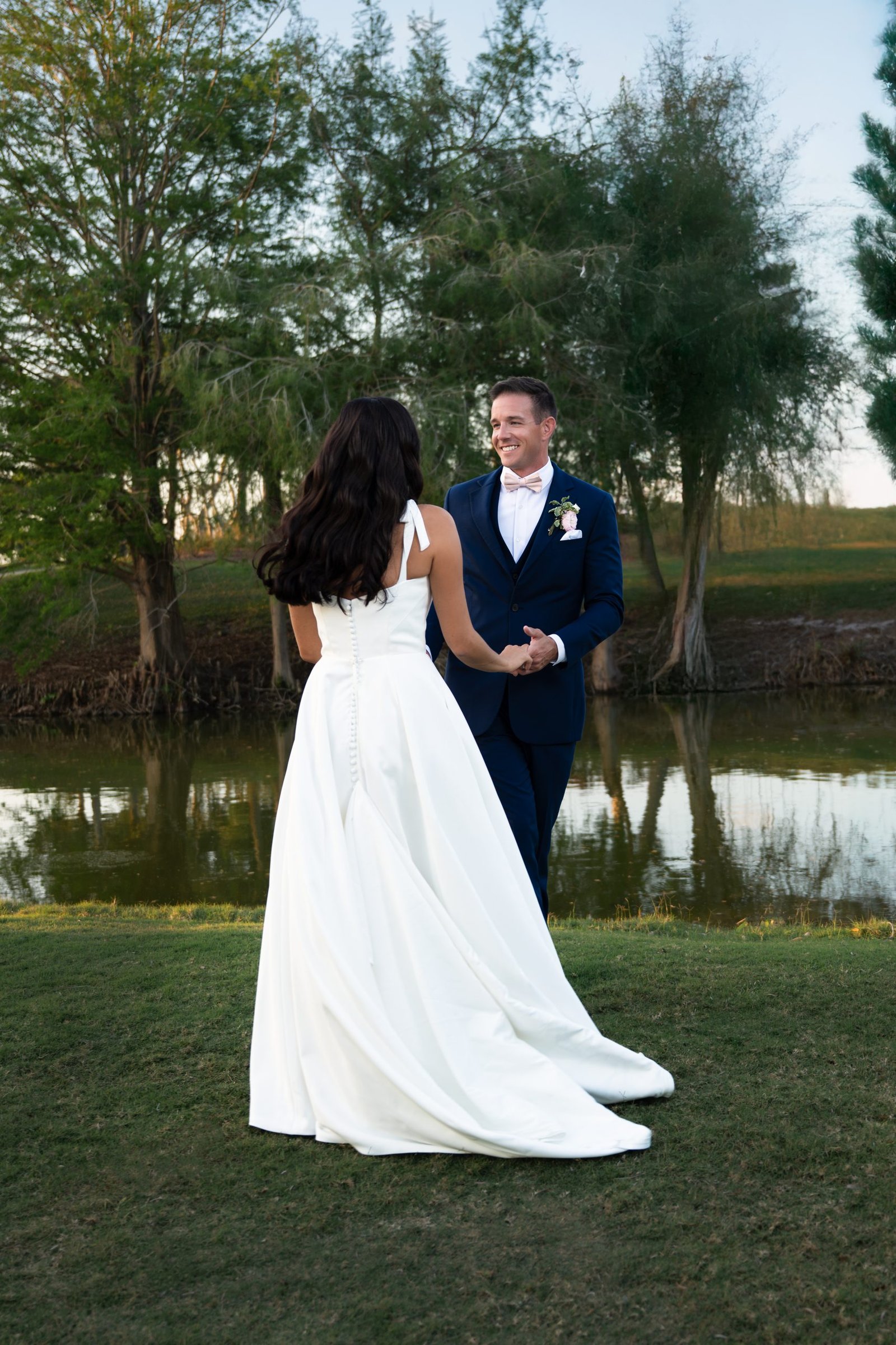 Newly married couple smiling and holding hands at The Club at Ibis in West Palm Beach, captured by Alito Photography, South Florida wedding photographer.