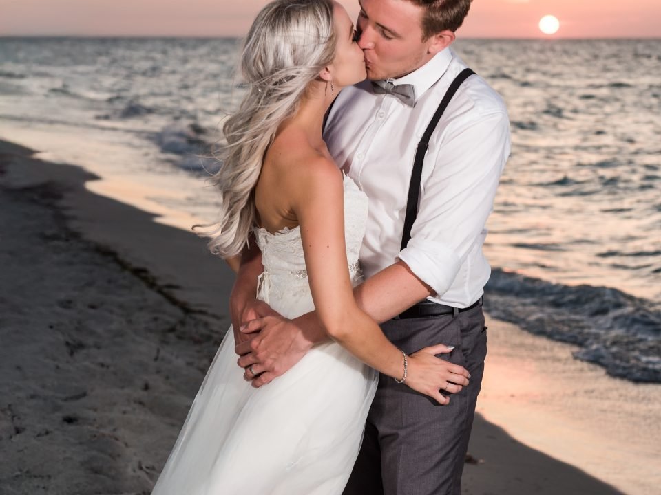 Newlyweds kissing on a Miami beach at sunset, photographed by Alito Photography for a South Florida wedding.