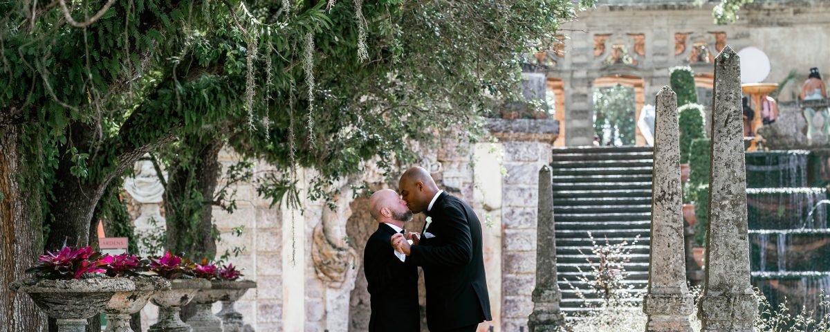 LGBTQ couple wedding portraits at Vizcaya Museum and Gardens captured by Alito Photography, featuring romantic poses among historic gardens and European-style architecture.